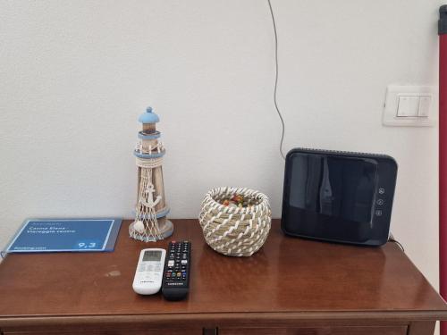 a table with a tv and a remote control on it at Casina Elena - Viareggio centro in Viareggio