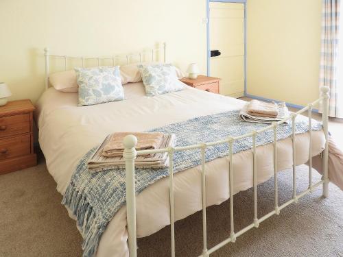 a bedroom with a white bed with a metal frame at West End Farmhouse in Barmston