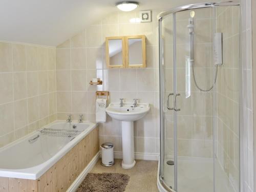 a bathroom with a tub and a sink and a shower at West End Farmhouse in Barmston