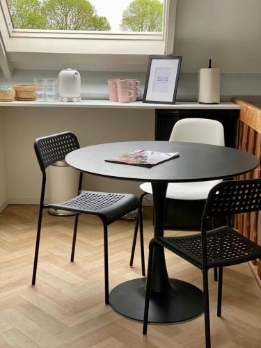 a table and chairs in a kitchen with a table at Guesthouse at the Amstel river with 2BR 2BA and garden in Amstelveen
