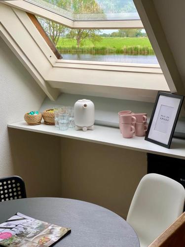 a window sill with a table and a laptop on it at Guesthouse at the Amstel river with 2BR 2BA and garden in Amstelveen