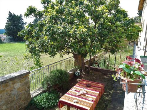 un tavolo da picnic sotto un albero accanto a una recinzione di La Casina dei nipoti a Strada