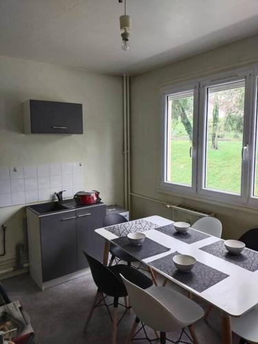 cocina con mesa, sillas, mesa y ventana en Appartement à 15mn du centre ville de Rouen en Canteleu