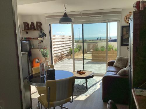 un salon avec un canapé et une table dans l'établissement Studio neuf,vintage,terrasse,wifi ,excellence face mer, à Saint-Hilaire-de-Riez