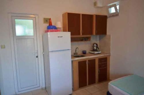 a kitchen with a white refrigerator and a window at Studio in Avşa Adası