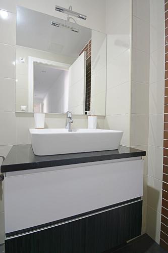 a bathroom with a white sink and a mirror at Apartamento con piscina en Portonovo, Sanxenxo in Portonovo