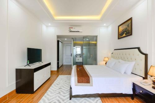 a bedroom with a white bed and a television at Seaside Boutique Resort Quy Nhon in Quy Nhon