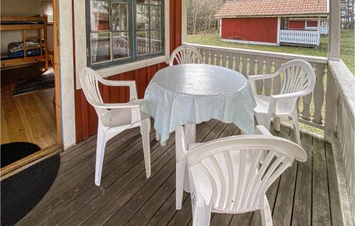 a table and chairs on the porch of a cabin at Cozy Home In Jälluntofta With Wifi in Jälluntofta