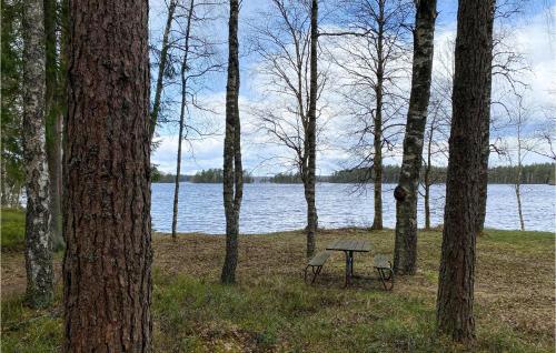 a picnic table and bench next to a lake at Cozy Home In Jälluntofta With Wifi in Jälluntofta