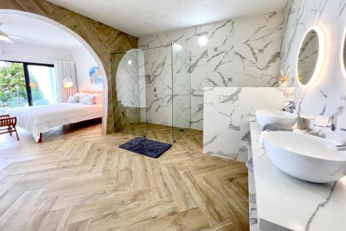 a bathroom with two sinks and a bed and a mirror at Domaine de la Falaise private villa in Souillac