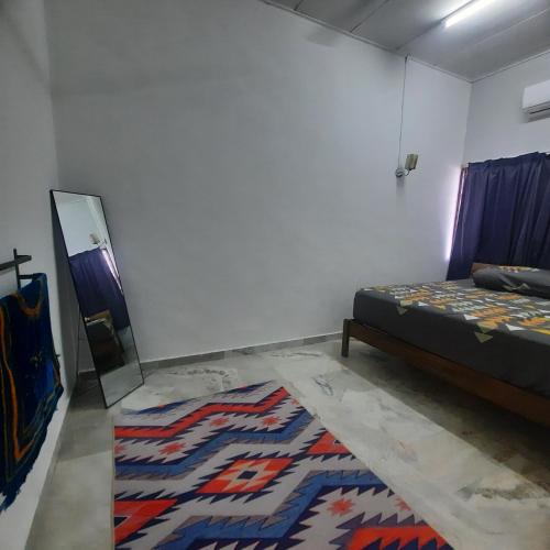 a bedroom with a bed and a rug on the floor at Homestay Sunnah Seri Manjung Islam in Seri Manjung