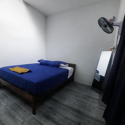 sypialnia z łóżkiem z niebieską pościelą i lustrem w obiekcie Homestay Sunnah Seri Manjung Islam w mieście Seri Manjung