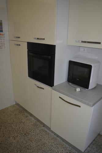 een keuken met witte kasten en een magnetron op een aanrecht bij La Terrazza su Portovenere in Portovenere