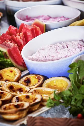 a table topped with bowls of dip and fruit at Logis Bagatelle - 51530 Dizy in Épernay