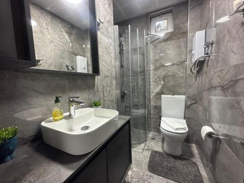 y baño con lavabo, ducha y aseo. en Flat with Shared Pool and Garden in Kalkan Antalya, en Kalkan