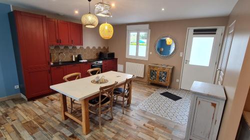 une cuisine avec une table et des chaises dans une pièce dans l'établissement Ô de Vents - à 30m de la plage, à Sangatte