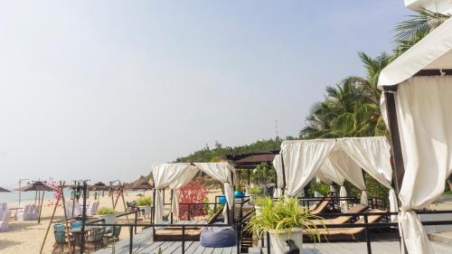 a beach with chairs and umbrellas and the ocean at Seaside Boutique Resort Quy Nhon in Quy Nhon
