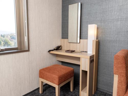 a bathroom with a vanity with a mirror and a stool at Tokyu Stay Kanazawa in Kanazawa