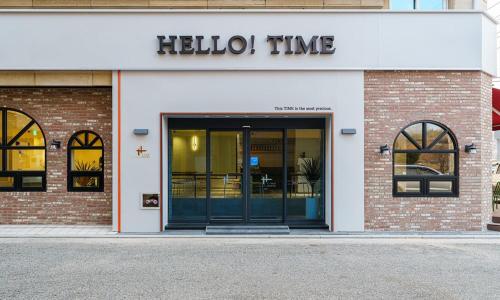 un devant de magasin avec une porte et un panneau indiquant les heures de réception dans l'établissement Gumi time hotel, à Gumi