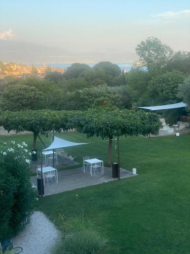 a picnic area with tables and umbrellas in a park at B&B Panorama Cinque in Salò