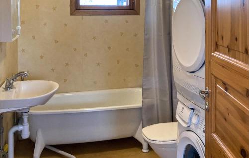 een badkamer met een bad, een wastafel en een toilet bij Cozy Home In Ljuster With Kitchen in Norra Ljustero