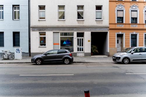 due auto parcheggiate di fronte a un edificio di Moderne Apartments City Stadtnah -JUNIK Apartments a Duisburg