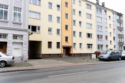 a building on the side of a street with parked cars at Moderne Apartments City Stadtnah -JUNIK Apartments in Duisburg