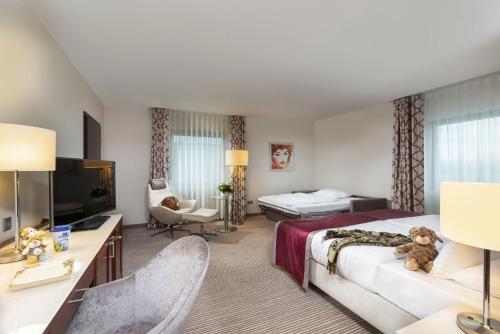 pokój hotelowy z łóżkiem i telewizorem w obiekcie Maritim Hotel Bonn w mieście Bonn