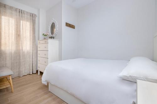 een witte slaapkamer met een wit bed en een dressoir bij BHost - Victoria 64 in Málaga