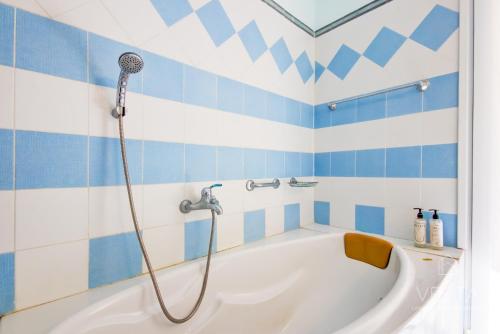 baño azul y blanco con bañera en Vintage Maisonette with 3-bdrms, Akti Elias Halkidiki, en Kalogria
