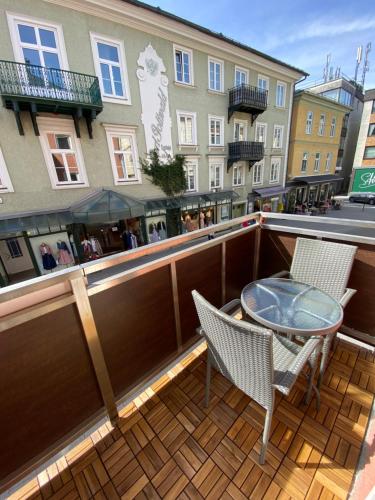 a balcony with two chairs and a table and a building at Rettenkogel im Zentrum von Bad Ischl in Bad Ischl
