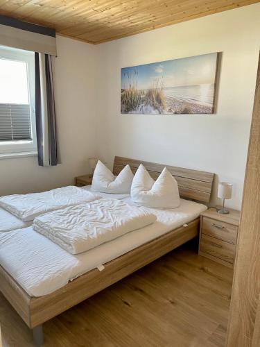 a bedroom with a bed with white sheets and a window at Altefähr Haus 42 in Altefähr
