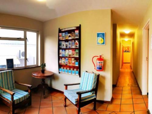 a waiting room with two chairs and a table at Dune Lodge in Hout Bay