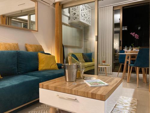 a living room with a blue couch and a table at Appartement de standing Le Velvet Bay climatisé en bord de mer in Antibes