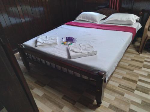 a bed with two towels and a pair of shoes on it at Homely Home stay in Kalpetta