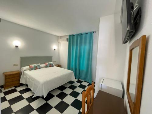 a bedroom with a bed and a checkered floor at Micaela Charming Hostal in Torremolinos