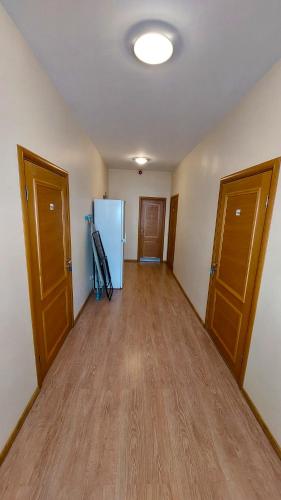 an empty room with a refrigerator and wooden floors at Happy Hotel in Rīga