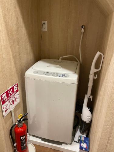 a small bathroom with a toilet and a toilet brush at W&J Dream Stay in Osaka