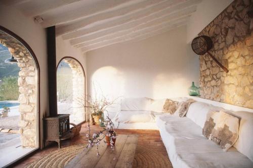 a living room with a white couch and a fireplace at Riurau de Maria in Parcent