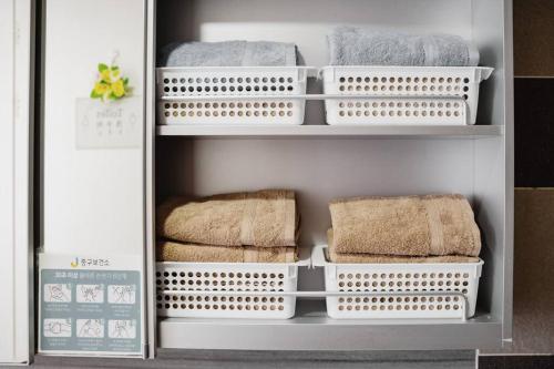 a refrigerator filled with white baskets and towels at Sky Cozy House in Seoul