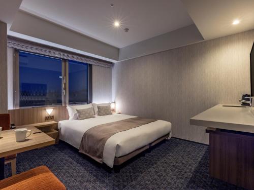 a hotel room with a bed and a sink at Tokyu Stay Kanazawa in Kanazawa