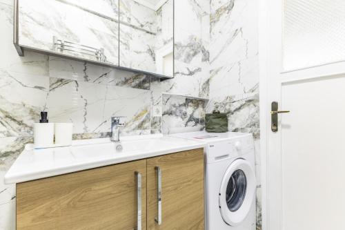a bathroom with a sink and a washing machine at Modern Stylish Cozy Flat in the Heart of Kadikoy in Istanbul