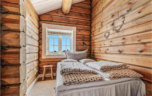 1 dormitorio con 1 cama en una pared de madera en 4 Bedroom Awesome Home In Drangedal, en Drangedal