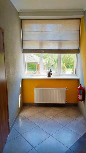 an empty room with a window and a tile floor at Happy Hotel in Rīga