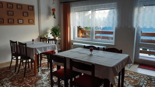 uma sala de jantar com duas mesas e cadeiras e uma janela em Pension Kristýna em Kašperské Hory