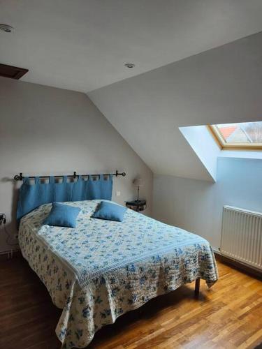 une chambre avec un lit avec des oreillers bleus dessus dans l'établissement Gîte Saint Mard, à Saint-Mard-lès-Rouffy