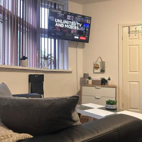 a living room with a couch and a flat screen tv at Bv Charming Studio with Free Private Parking, 10 Minutes from Town Centre in Huddersfield