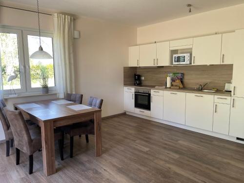 a kitchen with a wooden table and a dining room at Störtebeker 13 in Gnies