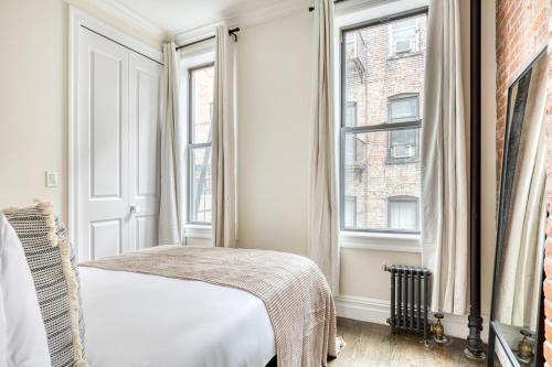 a bedroom with a bed and two windows at Nolita 1br w wd nr New Museum NYC-1037 in New York