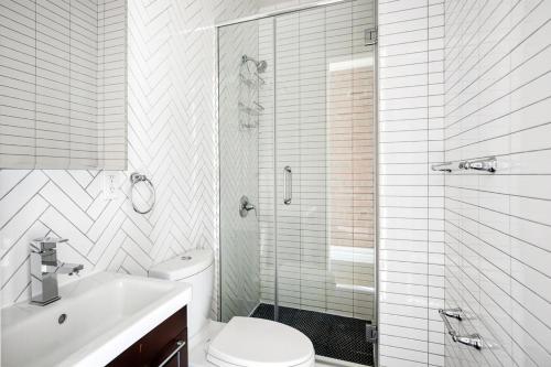 a bathroom with a toilet and a shower and a sink at Nolita 1br w wd nr New Museum NYC-1037 in New York